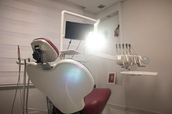 a dental room with a chair and a monitor