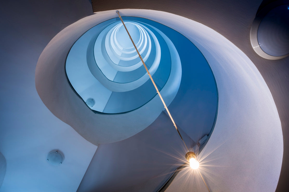 a circular light fixture hanging from the side of a wall